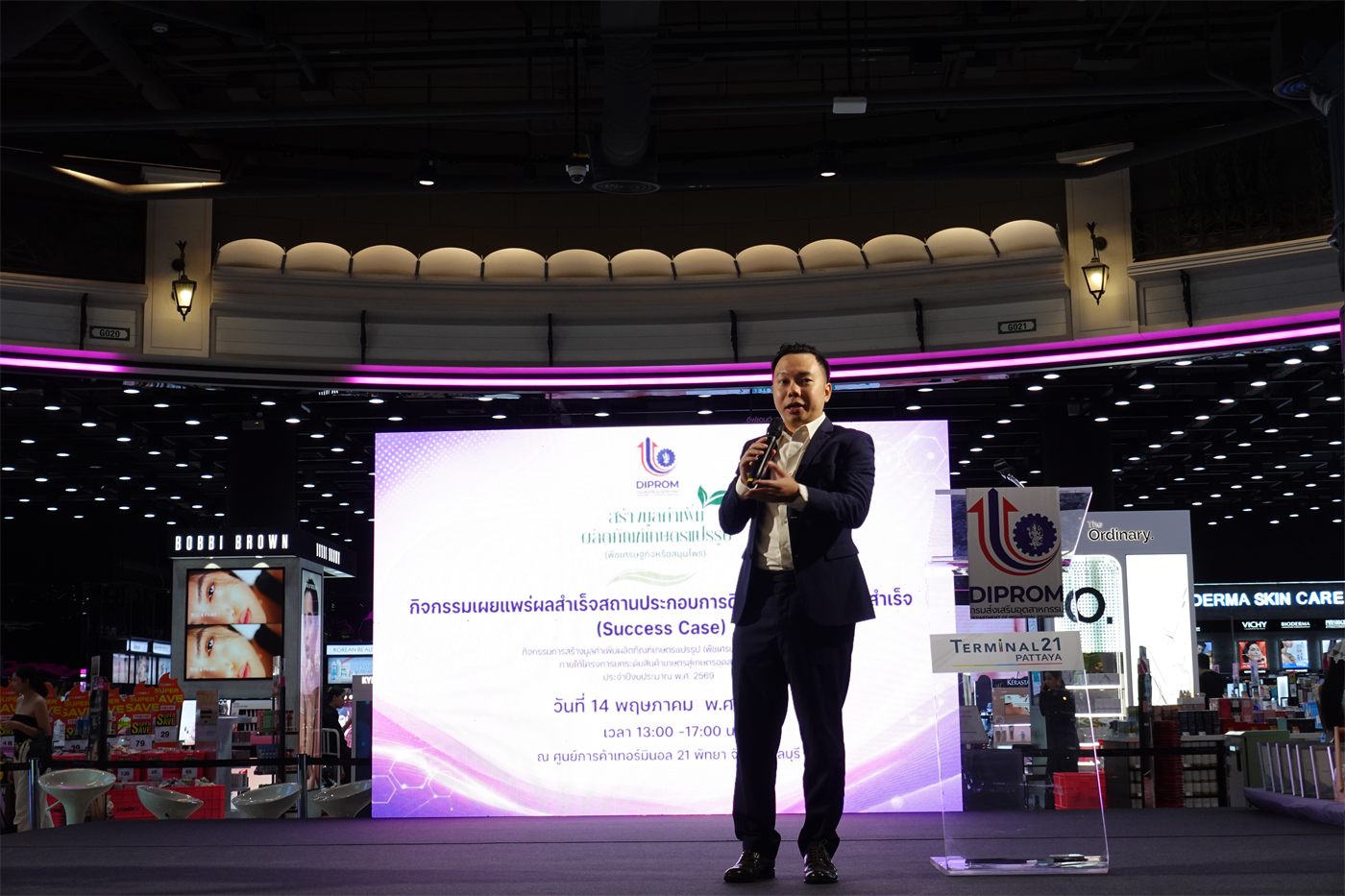 Coach Tum as guest speaker on stage at a DIPROM government event